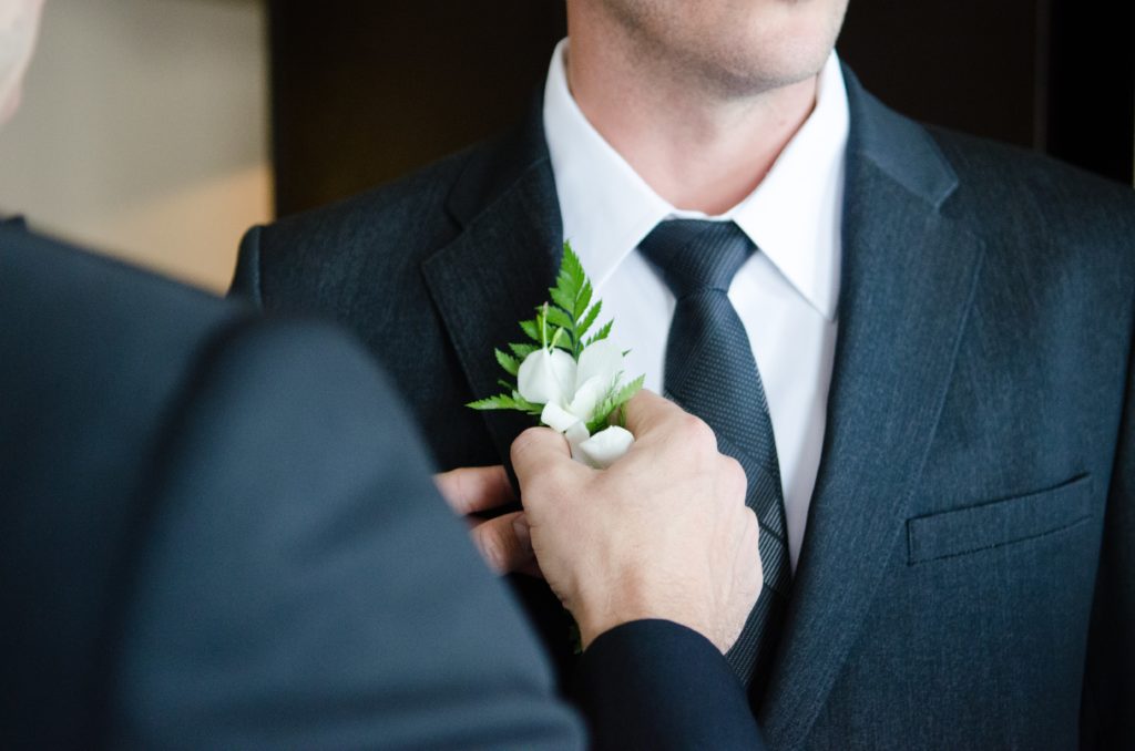 Best man pinning Boutonniere on groom before the wedding