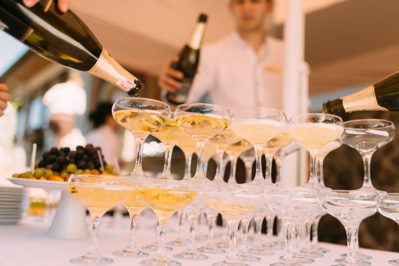 Staff filling champagne glasses at wedding